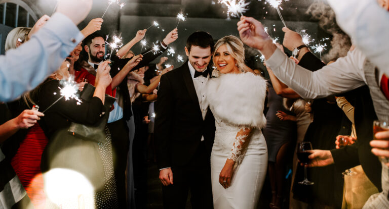 Bride and groom walk through sparkler exit on wedding day at Clonabreany House in Ireland