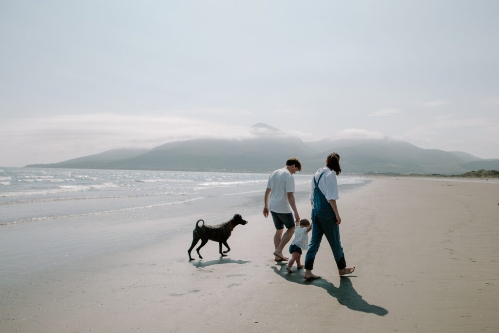 family walk on beach with pet dog at murlough beach