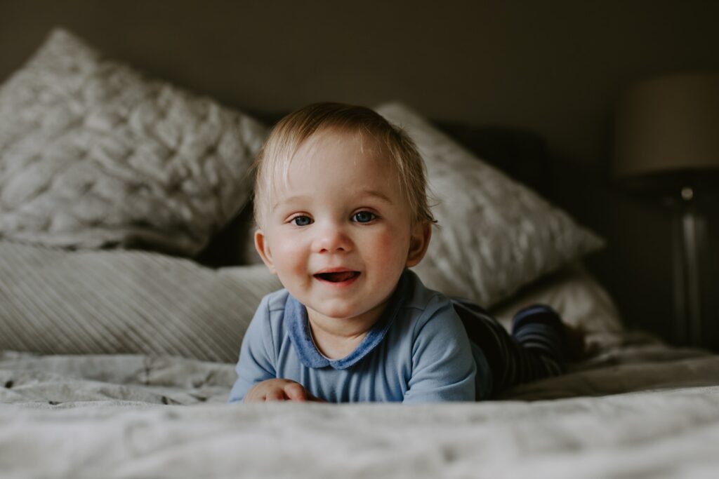 baby boy smiling on bed
